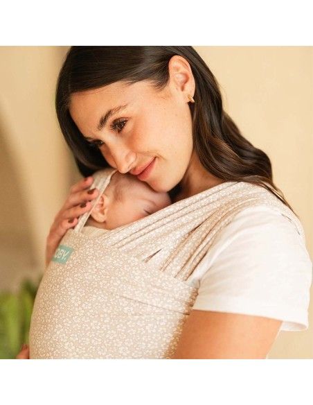 Madre porteando a bebé pequeño con fular elástico de algodón Moby Coastal Blooms