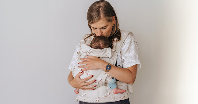 Madre porteando a bebé con mochila portabebés Fidella Fusion Baby