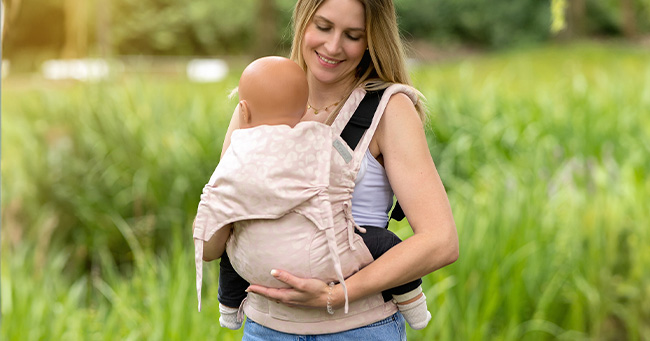 Madre porteando a bebé con mochila portabebés Fidella Fusion Baby